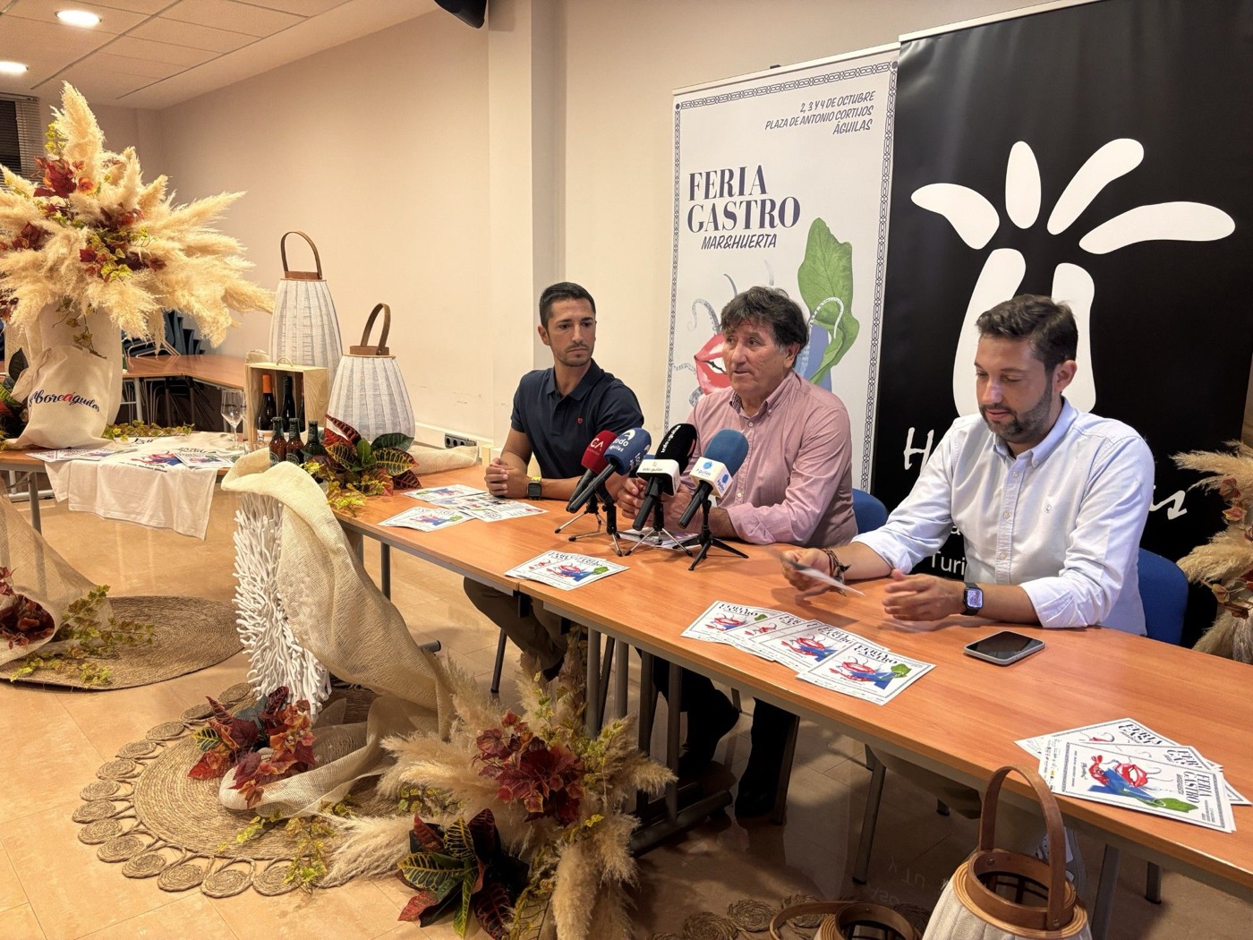 Presentación de SaboreÁguilas 26, con el cartel de la feria de fondo
